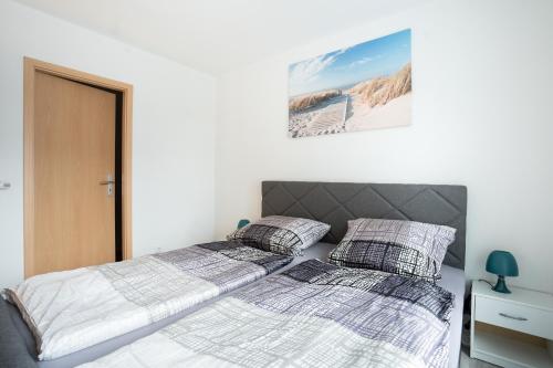 爱尔福特CaSa Apartment Svea - 2x Parken-Amazon Prime-Terasse-Garten-Vollausstattung的卧室设有2张床和白色的墙壁。