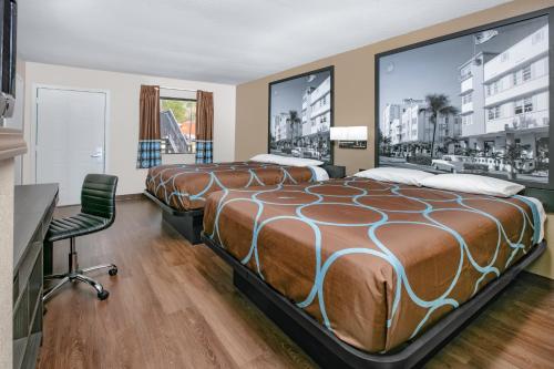 莫斯波因特Super 8 by Wyndham Moss Point的酒店客房配有两张床和一张书桌