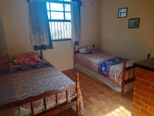 阿拉鲁阿马Cantinho da Lagoa的一间卧室设有两张床和窗户。