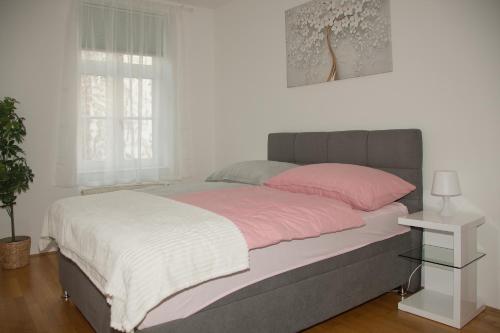 维也纳Blue Lotus Apartment的一间卧室配有一张大床,铺有粉色和白色的床单。