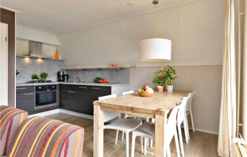 VlagtweddeAwesome Home In Vlagtwedde With Kitchen的厨房配有木桌和一些椅子