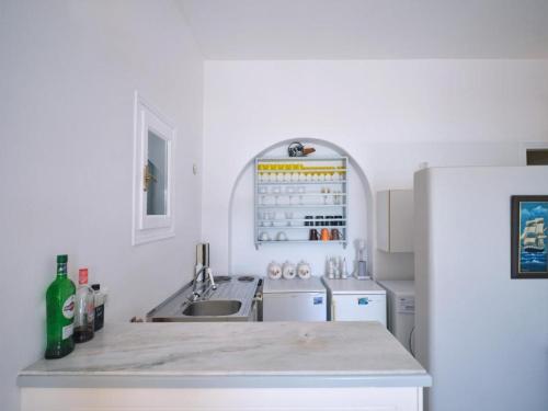 纳乌萨VILLA ALEXANDROS的白色的厨房配有水槽和冰箱