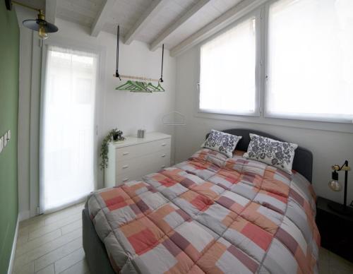 马罗内La brezza del lago的一间卧室设有一张大床和两个窗户。