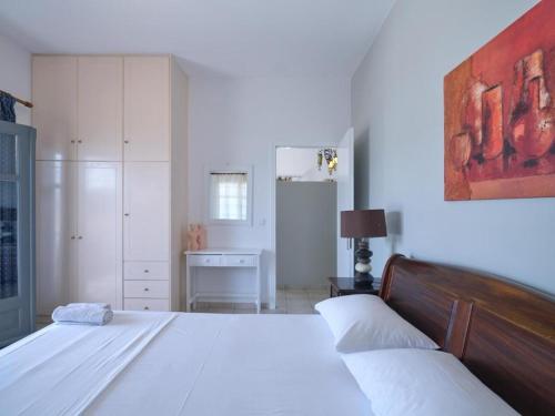 纳乌萨VILLA ALEXANDROS的一间白色卧室,配有两张床和一张书桌
