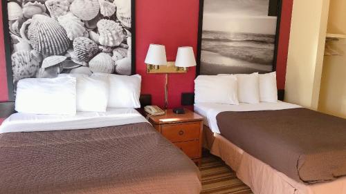 默特尔比奇Royal Palace Inn and Suites Myrtle Beach Ocean Blvd的酒店客房设有两张床和电话