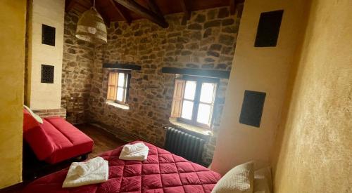 莱昂Elpajardeportilla的一间卧室设有红色的床和2个窗户。