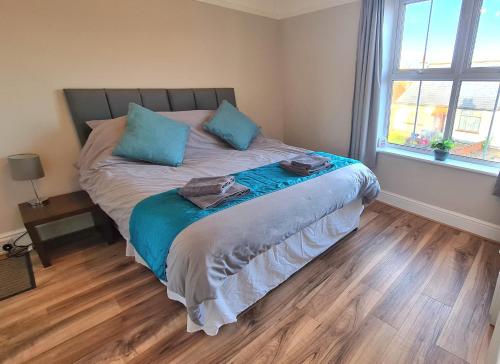 雷利Castle Cottage的一间卧室配有一张带蓝色枕头的床和一扇窗户。