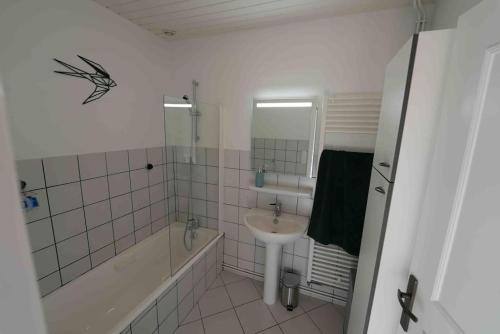 沙勒马泽勒Votre appartement à Chalmazel的白色的浴室设有水槽、浴缸和水槽。