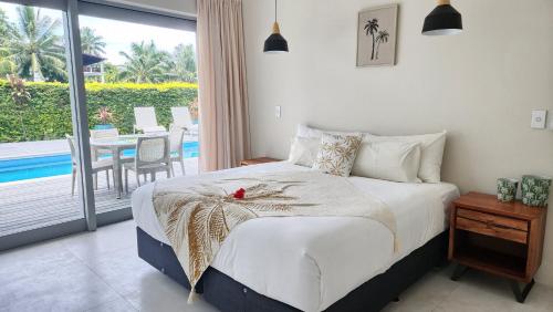 NgatangiiaMama Taras Luxury Villa的一间卧室配有一张床,阳台配有桌子