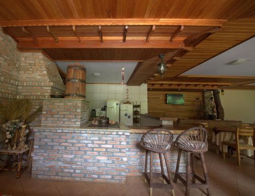 伊瓜苏普萨达松豪梅佛兹酒店的厨房配有2张凳子和砖砌柜台