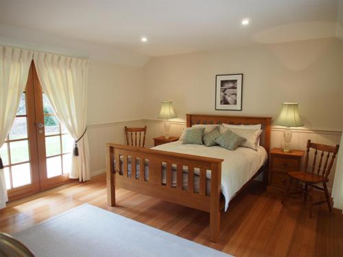 德洛兰塔哈拉度假屋的一间卧室配有一张带两把椅子的床和一扇窗户