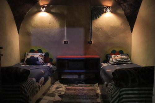 阿斯旺Carmah Guest house的一间设有两张床的客房,墙上有灯