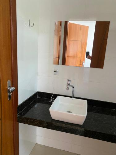 塞古罗港Seu apartamento em Porto的浴室设有白色水槽和镜子