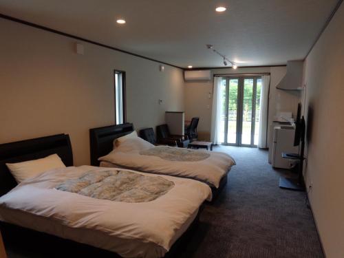 河津町Villa House Hisago - Vacation STAY 61410v的酒店客房设有两张床和电视。