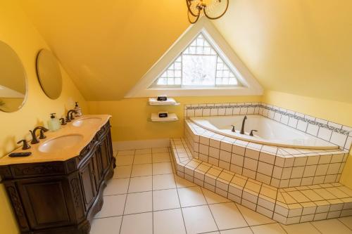 海伦娜Pope House - Hist. Mansion - The Green Suite的浴室配有天窗、浴缸和水槽。