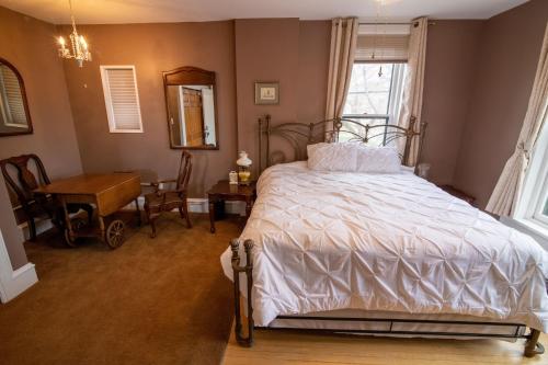 海伦娜Pope House - Hist. Mansion - The Gold Rush Suite的一间卧室配有一张床、一张桌子和一面镜子