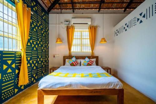 果阿旧城Luxury 6 BHK Villa with Private Swimming Pool的一间卧室配有黄色和蓝色窗帘的床
