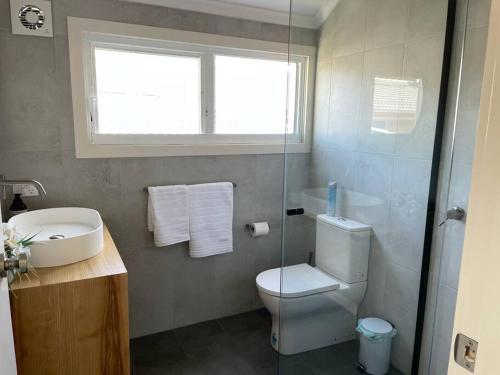 麦夸里港Noahs Beach House - at Flynns的一间带卫生间、水槽和窗户的浴室