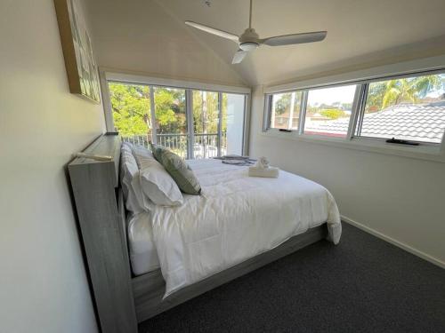 麦夸里港Noahs Beach House - at Flynns的一间卧室配有一张带白色床单和窗户的床。