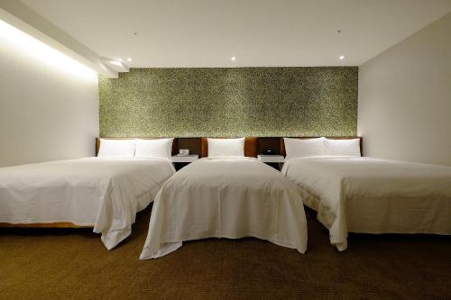 台北璞涟商务旅馆台北车站馆的带3张白色床单的床的房间
