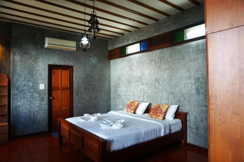 清迈Tamnak Lanta @Chiang Mai的一间卧室配有一张带白色床单的大床