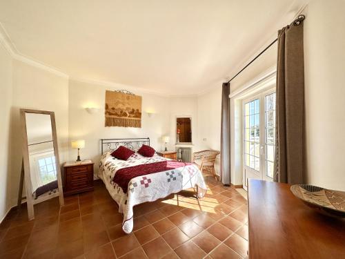 本萨夫林Casa da Aldeia的一间卧室配有一张床和镜子
