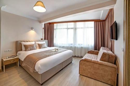 伊斯坦布尔SEVEN ROSES APART HOTEL的酒店客房带一张大床和一把椅子