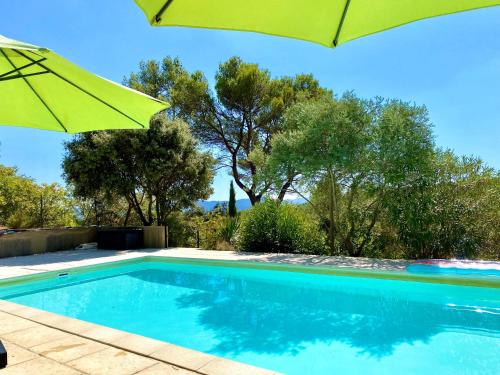 洛里Mas d'Olea的一个带绿伞和树木的游泳池