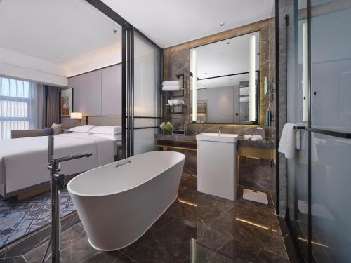鞍山鞍山希尔顿逸林酒店的带浴缸的浴室和卧室