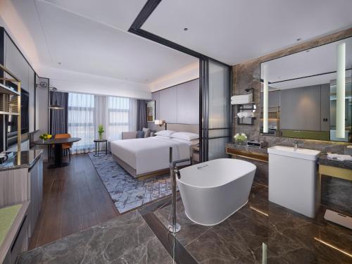 鞍山鞍山希尔顿逸林酒店的酒店客房配有一张床和浴缸。