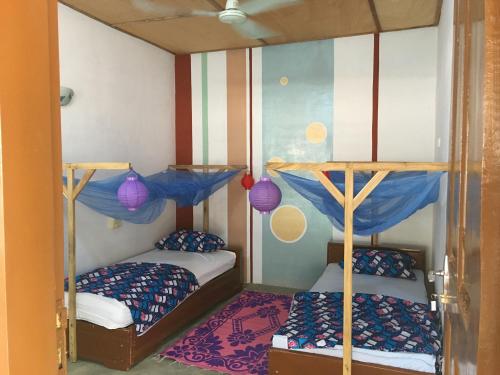 OuidahCDAC Elijah - Espace Culturel的一间客房内配有两张双层床的房间