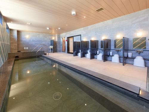 鹿儿岛Henn na Hotel Kagoshima Tenmonkan的游泳池,位于带游泳池的建筑内