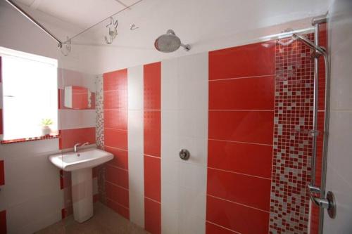 上瓦特法尔Climber's house的红色和白色的浴室设有水槽和淋浴