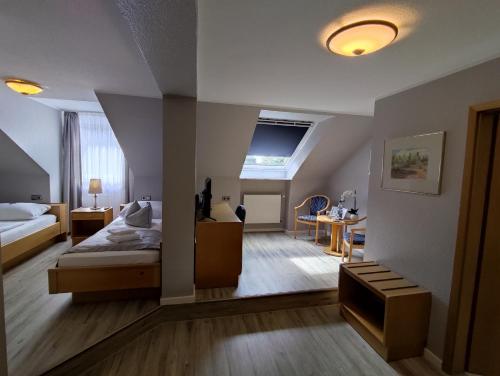 林根尊姆马赫瓦尔德酒店的一间卧室配有一张床和一张书桌