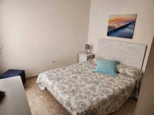 圭马尔Apartamento Zona Rural的一间卧室配有一张带蓝色枕头的床
