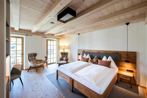 奥伯古格尔Hotel Grünerhof的一间卧室设有一张大床和木制天花板