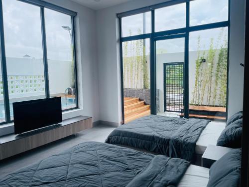 归仁Ri Rot villa - Venuestay的一间卧室配有两张床和一台平面电视