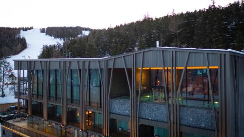 瓦尔道拉Olangerhof Hotel & Spa的一座带玻璃窗的建筑,山中