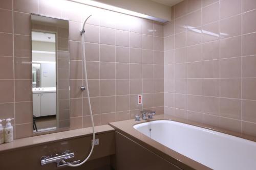 伊东Wellness Forest Ito - Kyoritsu Resort的带浴缸和镜子的浴室