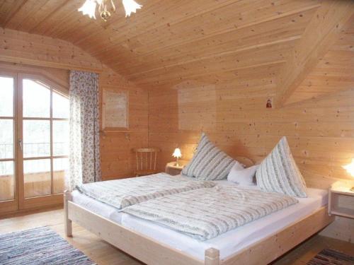 巴特法伊尔恩巴赫Braunhof的木制客房内的一间卧室配有一张大床