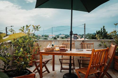 蓬德利马Villa Henriques的阳台的桌子和雨伞