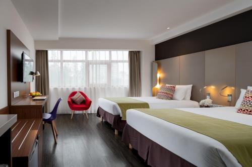 西安康铂酒店（西安钟楼回民街店）的酒店客房,设有两张床和一张红色椅子