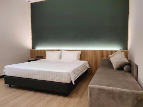 阿罗士打Urban Inn, Alor Setar的一间卧室配有一张床和一张沙发