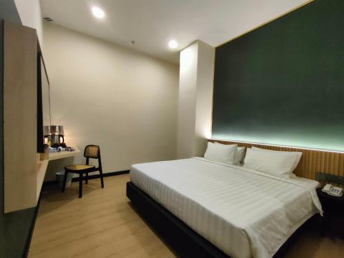 阿罗士打Urban Inn, Alor Setar的卧室配有一张大床,墙上设有绿板