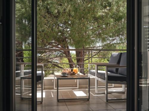 扎金索斯镇La Palma Apartment的庭院设有两把椅子、一张桌子和一扇窗户。