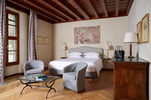 卡拉瓦吉斯德拉海滨QC Termegarda Spa & Golf Resort的一间卧室配有一张床、两把椅子和一张桌子