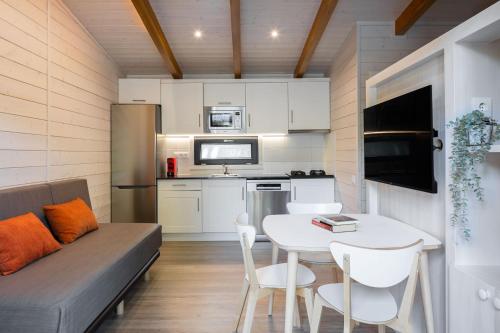 坎普罗东坎普罗东山谷露营酒店的小厨房配有白色的桌子和沙发
