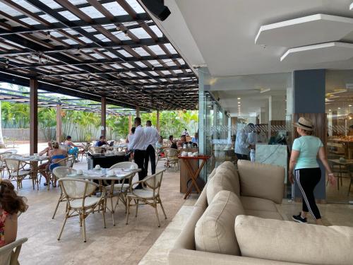 卡塔赫纳Playa -Boquilla -Condominio dentro de Hotel Sonesta的餐厅配有沙发和桌子,还有人用餐