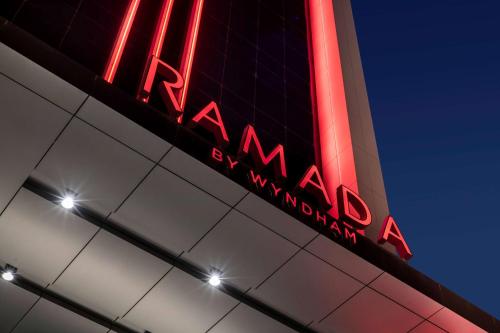 利雅德Ramada by Wyndham Riyadh King Fahd Road的建筑物一侧的红 ⁇ 虹灯标志