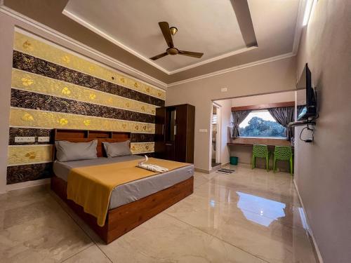 瓦加蒙Green Palace Resort的一间卧室配有一张床和一台电视